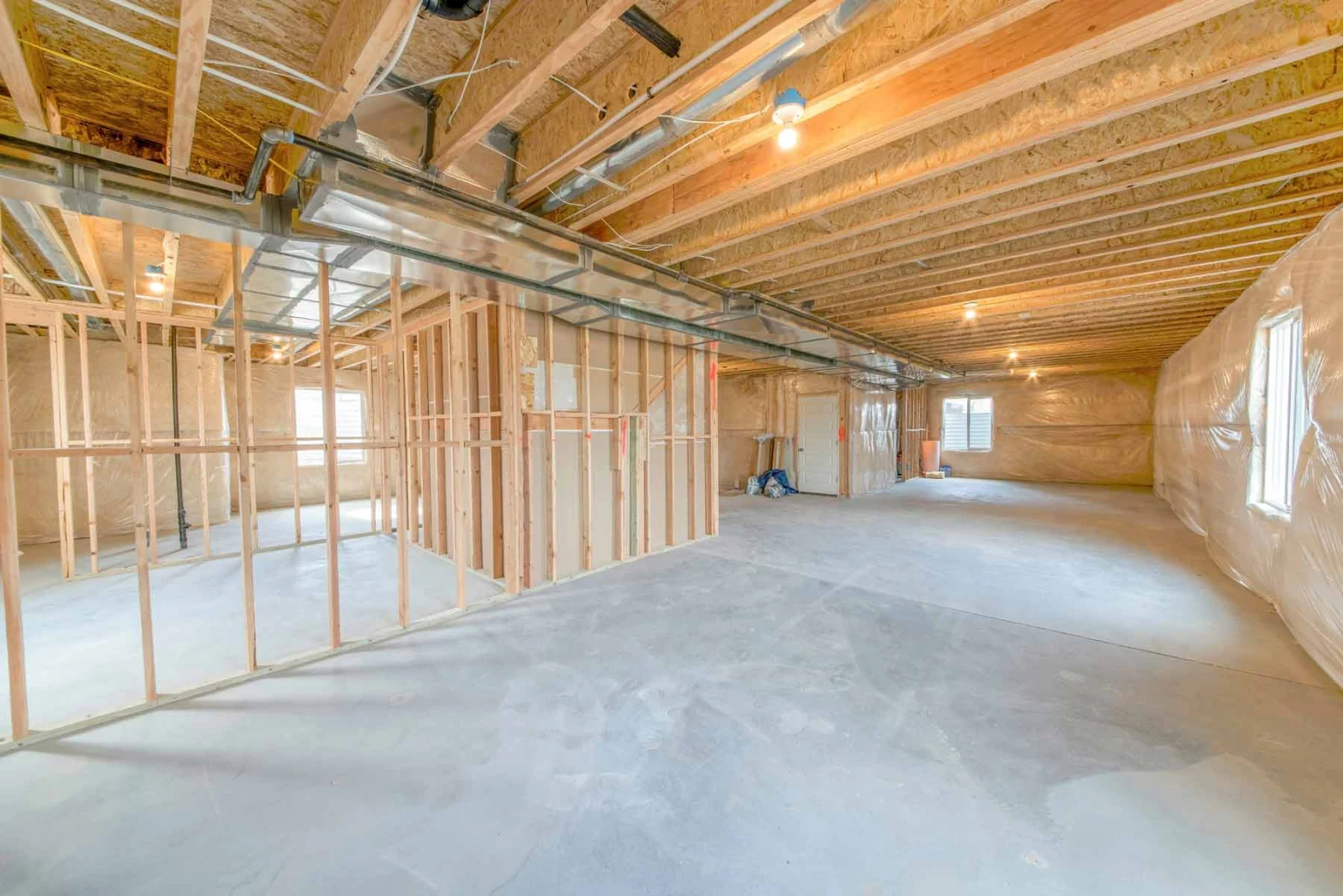 Basement being finished with new stud walls, ducting and a bare concrete floor