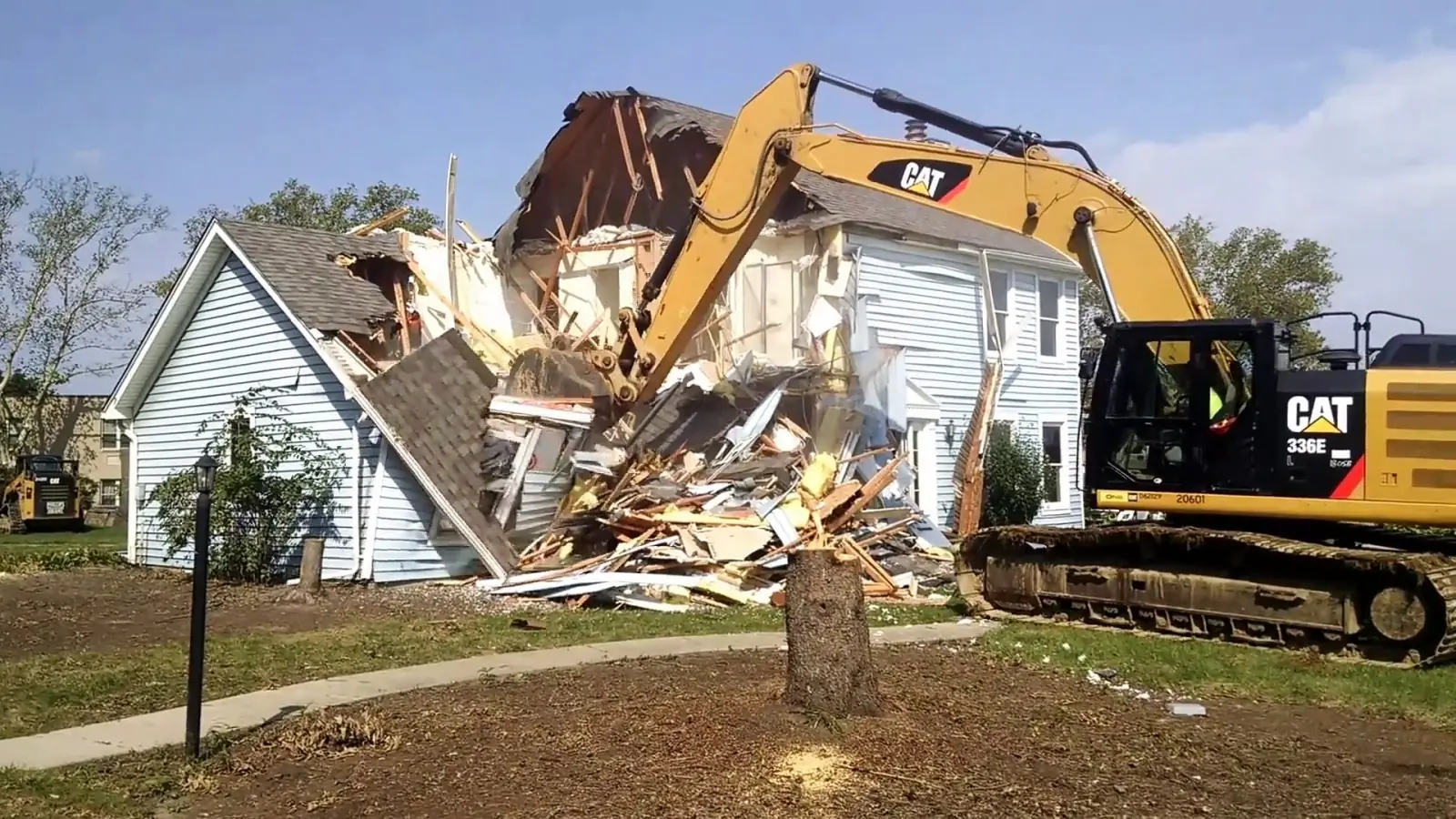 Excavator pulling down a house during a residential demolition